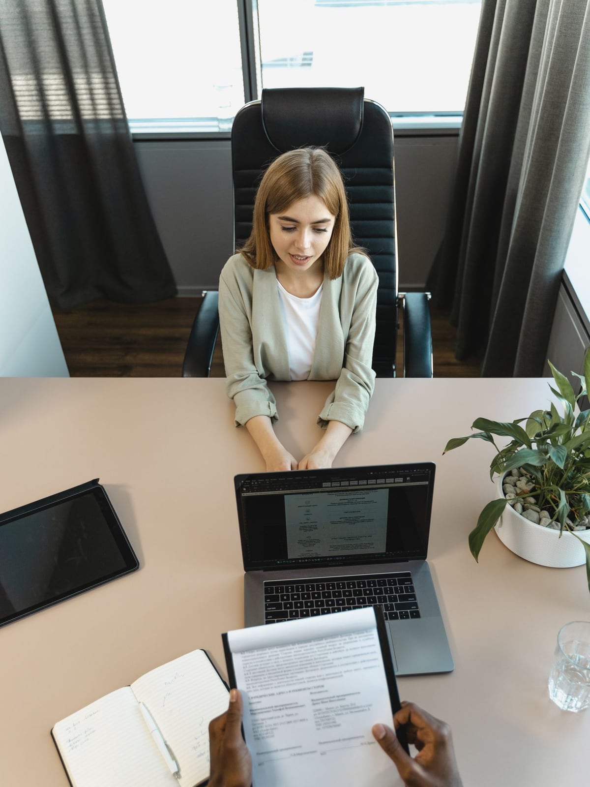 An editor conducting an interview with a business owner in a modern Innsbruck office.